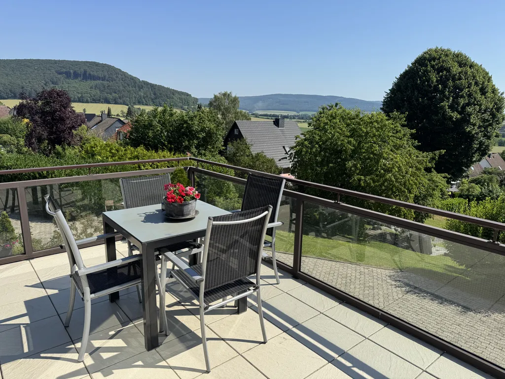 Großzügige Sonnenterrasse mit modernen Gartenmöbeln und herrlichem Panoramablick ins Grüne.