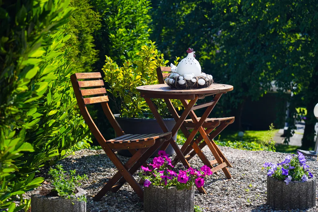 Idyllische kleine Holz-Sitzgruppe im sonnigen Garten, liebevoll dekoriert.