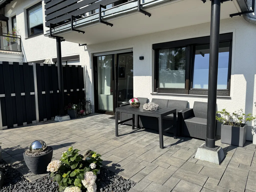 Eigene Terrasse der Ferienwohnung mit Sitzmöbeln, direktem Gartenzugang und privatem Parkplatz in Salzhemmendorf.