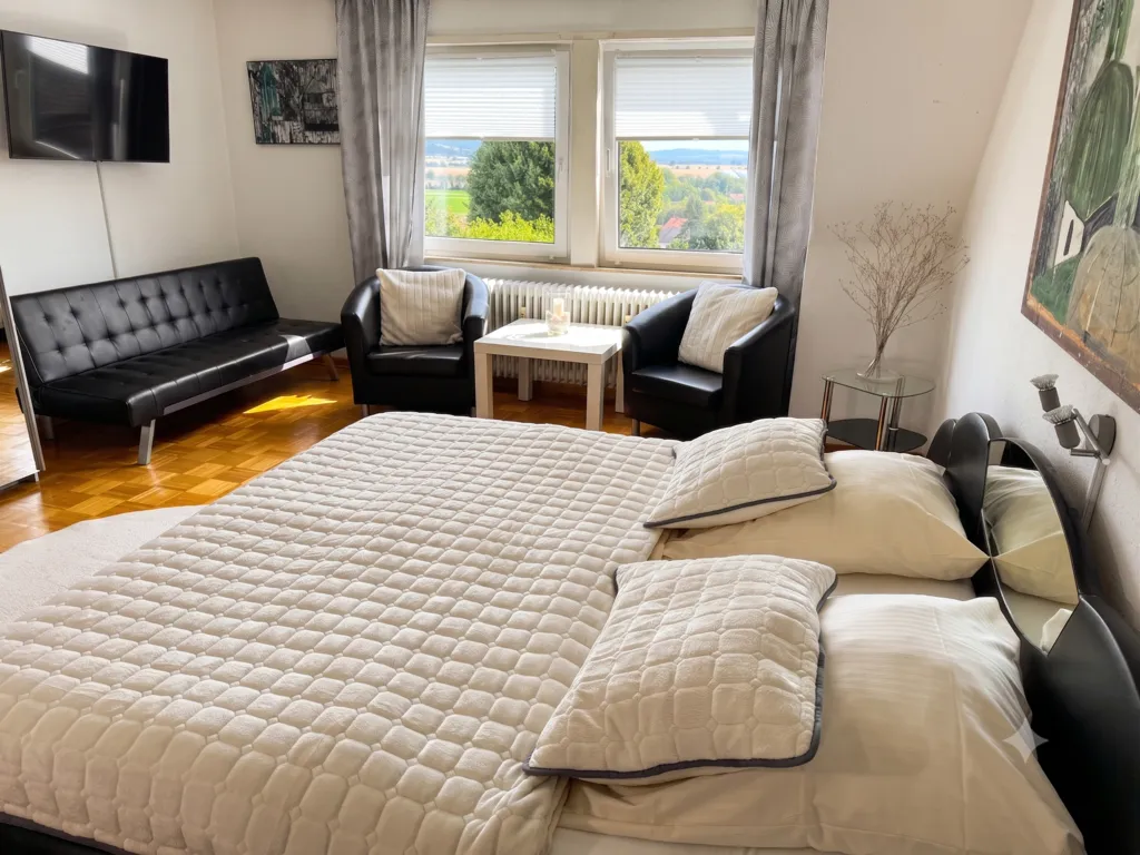 Großzügiges Schlafzimmer mit bequemem Doppelbett und herrlichem Ausblick auf die Natur des Weserberglands.