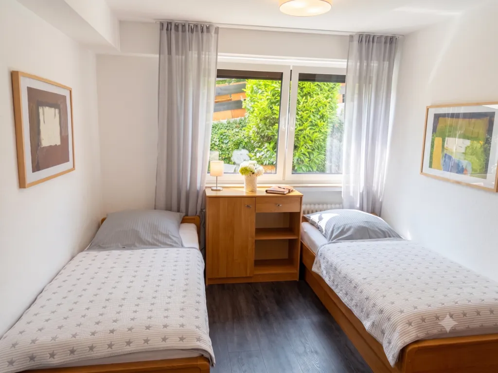 Komfortables, großes Zweibettzimmer mit getrennten Betten und modernem Badezimmer, ideal für Monteure oder Freunde.